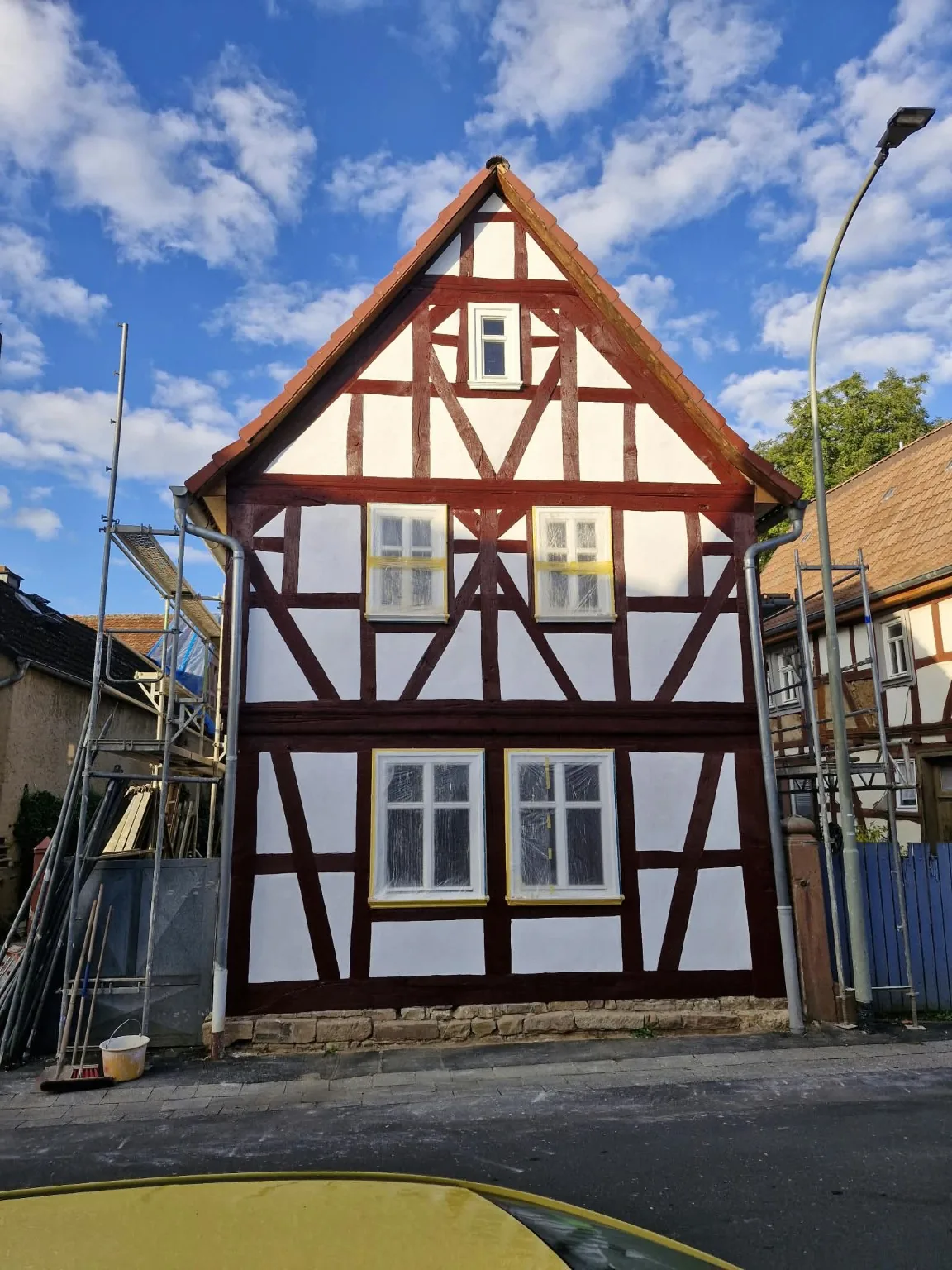 Instandgesetzte Fachwerkfassade mit hellen Gefachen und dunkelrotem Fachwerk